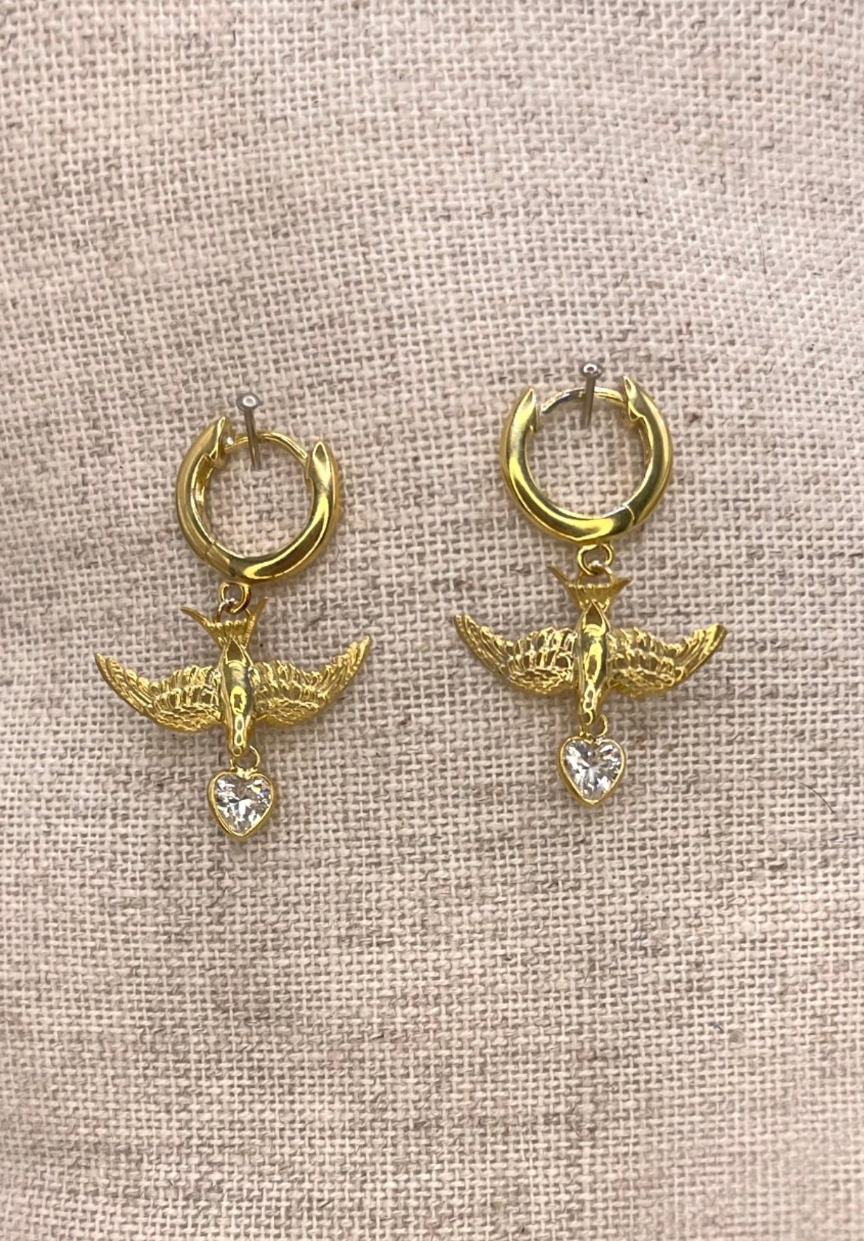 Small gold swallow earrings on clicker hoops, heart charm