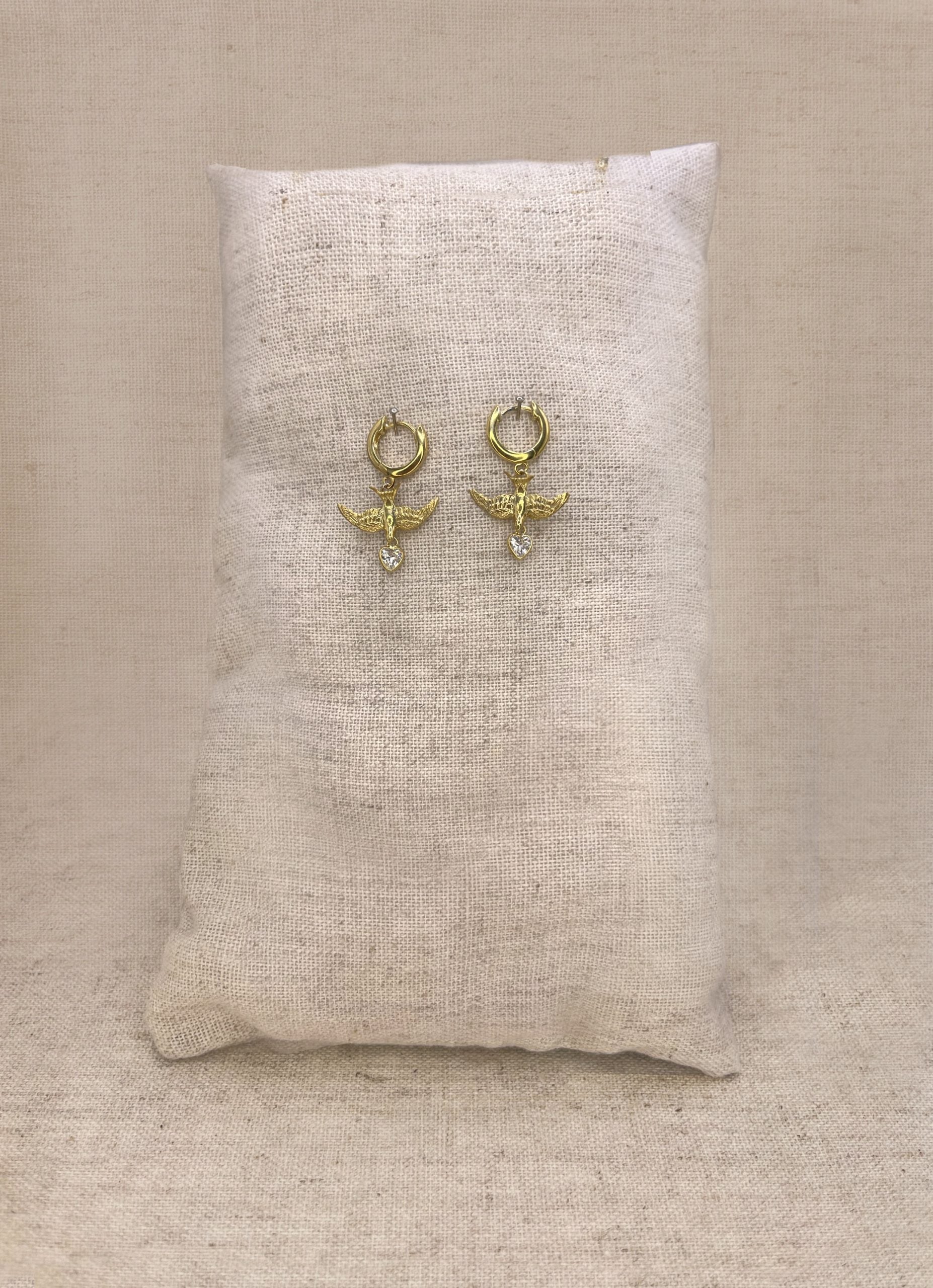Small gold swallow earrings on clicker hoops, heart charm